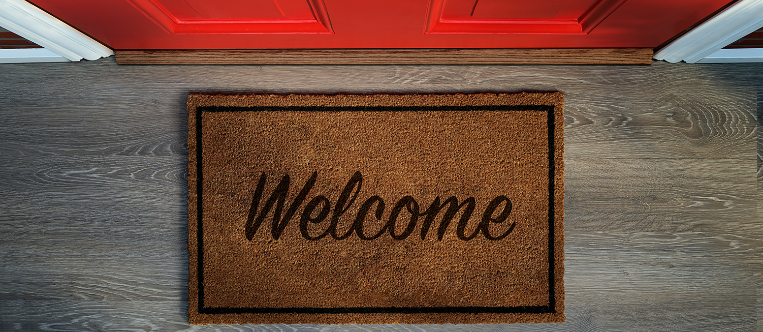 Overhead view of welcome mat outside inviting front door of house