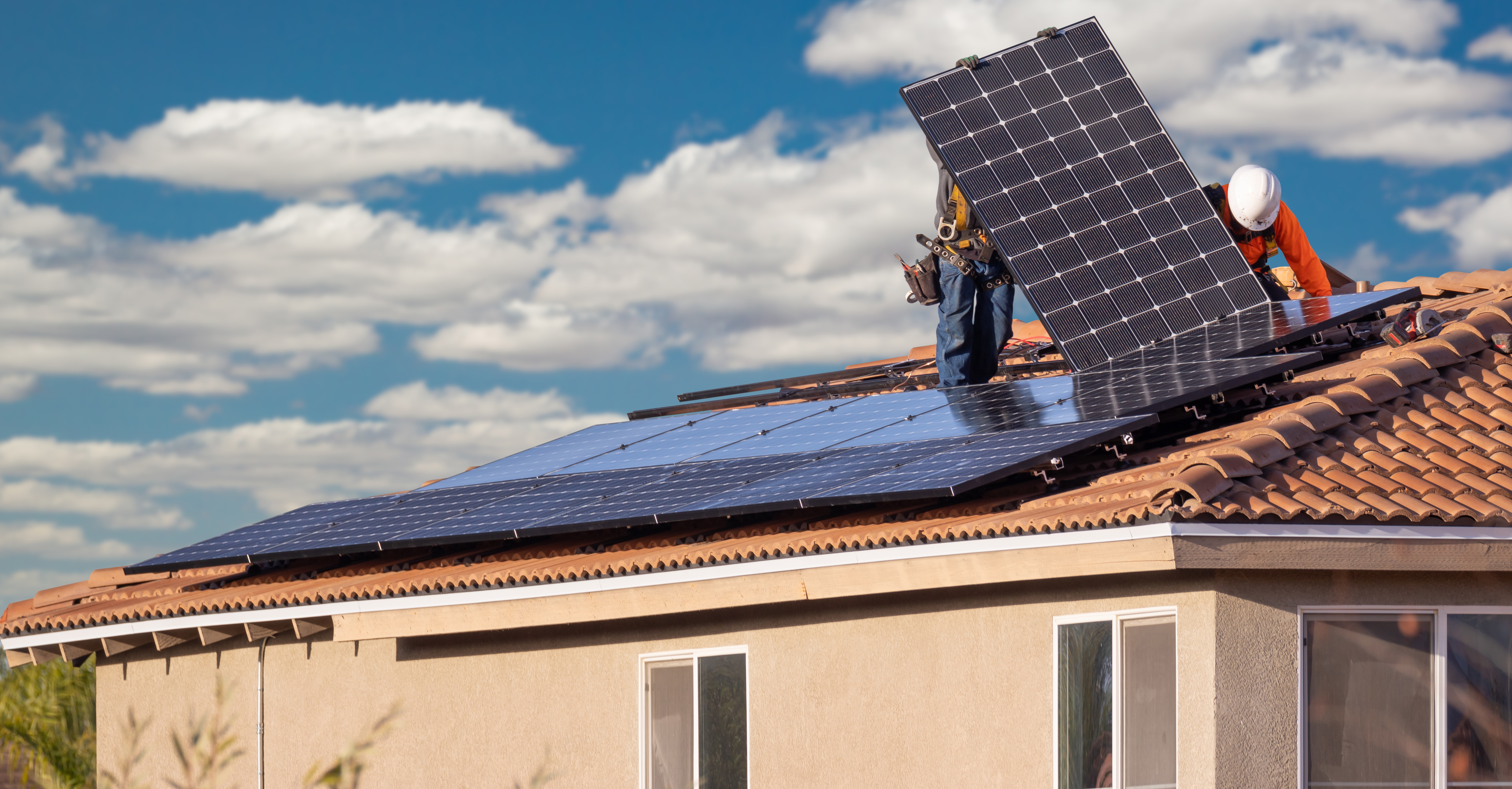 Workers Installing Solar Panels on House Roof.