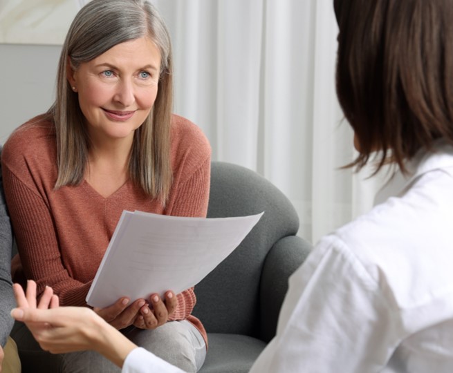 2 women talking with documents