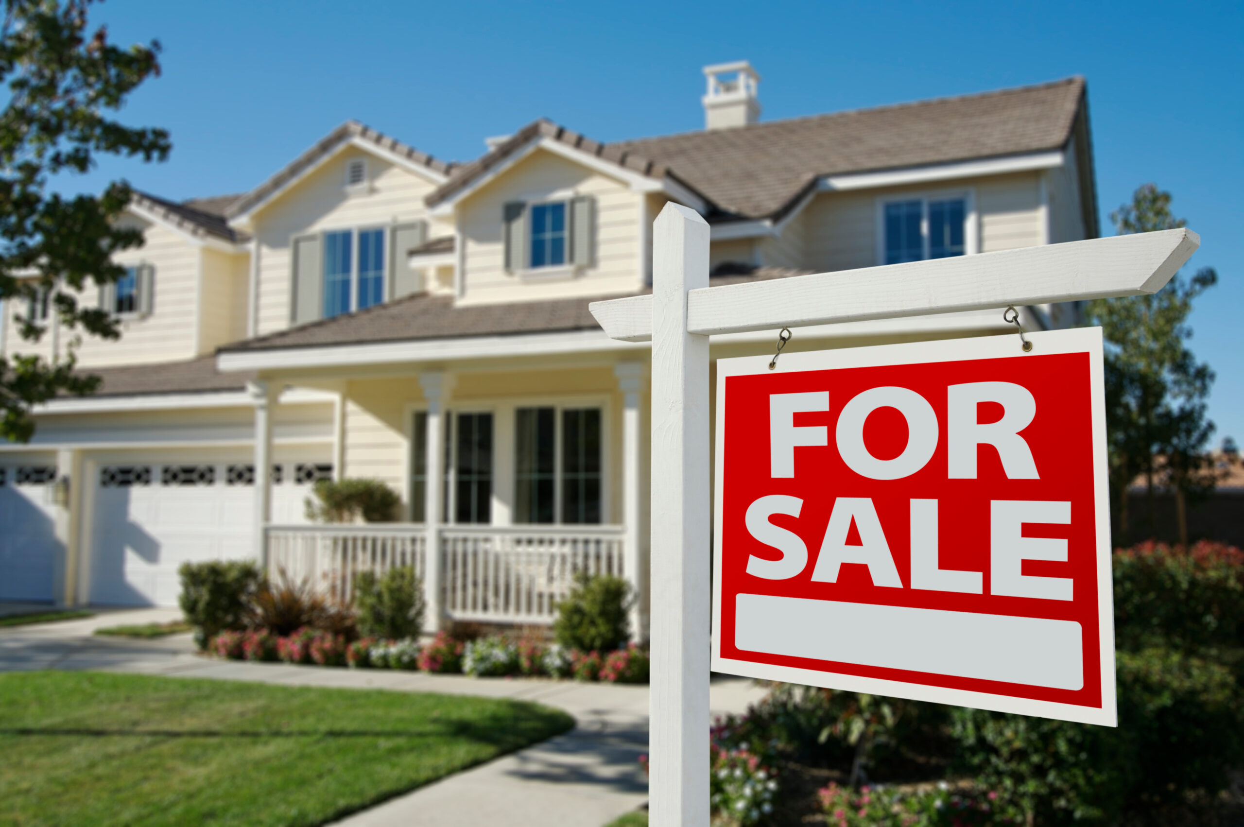 home for sale sign with house in background