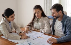 Realtor advising clients at table with paperwork